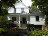 Older Bennington Heights home with a lovely porch, surrounded by greenery